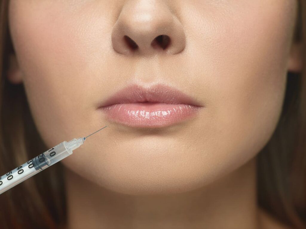 Chica recibiendo inyeccion de aumento de labios