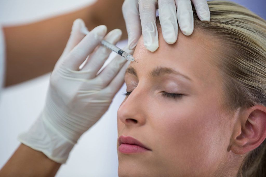 Mujer recibiendo tratamiento de neuromoduladores en frente