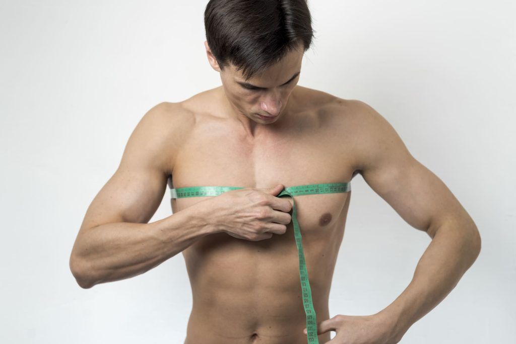 Hombre midiéndose el pecho con una cinta métrica
